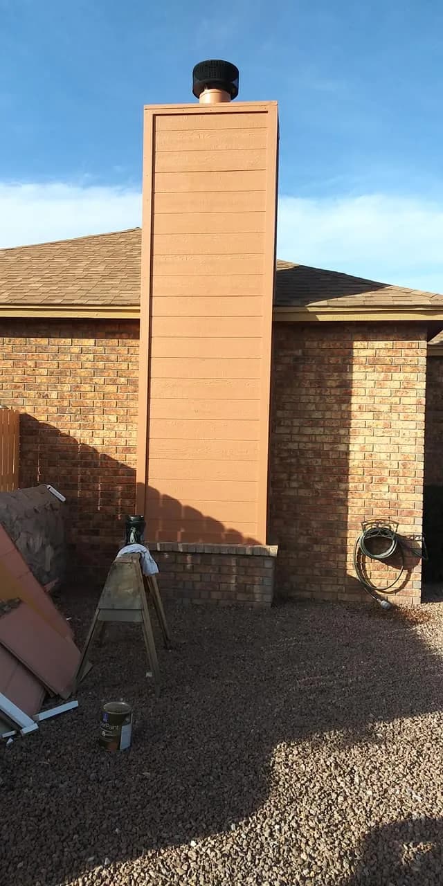 Tall chimney chase clad in new lap siding and painted to match a brick house