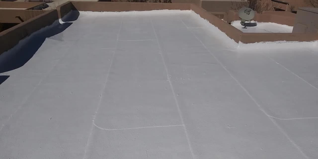 Newly coated white flat roof with sealed seams running its length
